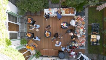 Un patio al aire libre con mesas y sillas redondas, rodeado de diversas estaciones de comida y bebidas.
