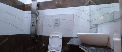 A modern bathroom with a bidet, a sink, and a mirror.