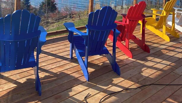 A wooden deck with colorful Adirondack chairs overlooking a body of water. - Secluded Sinclair Island Cliff with Water View and amazing SUNSETS (Trenton)