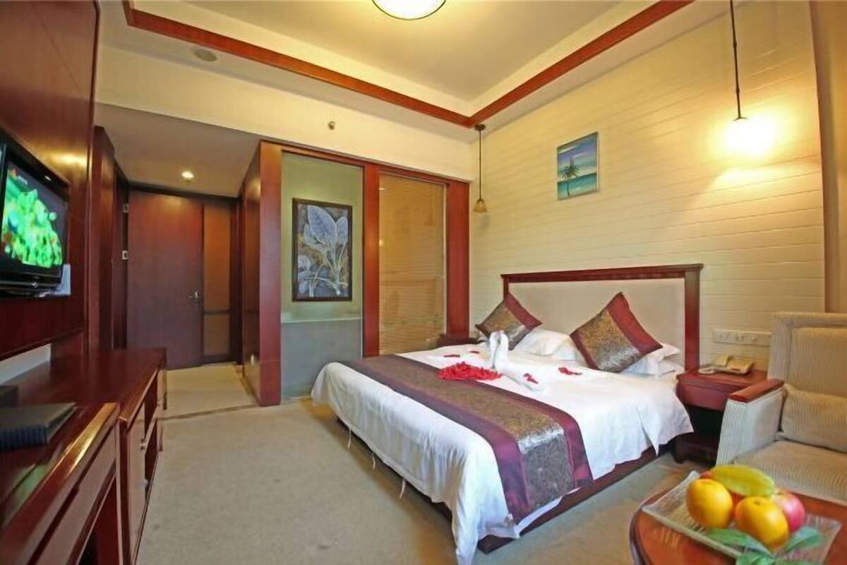 A hotel room with a bed, a television, a desk, and a chair.