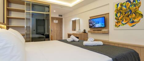 A hotel room with a bed, a wardrobe, a television, and a painting on the wall.