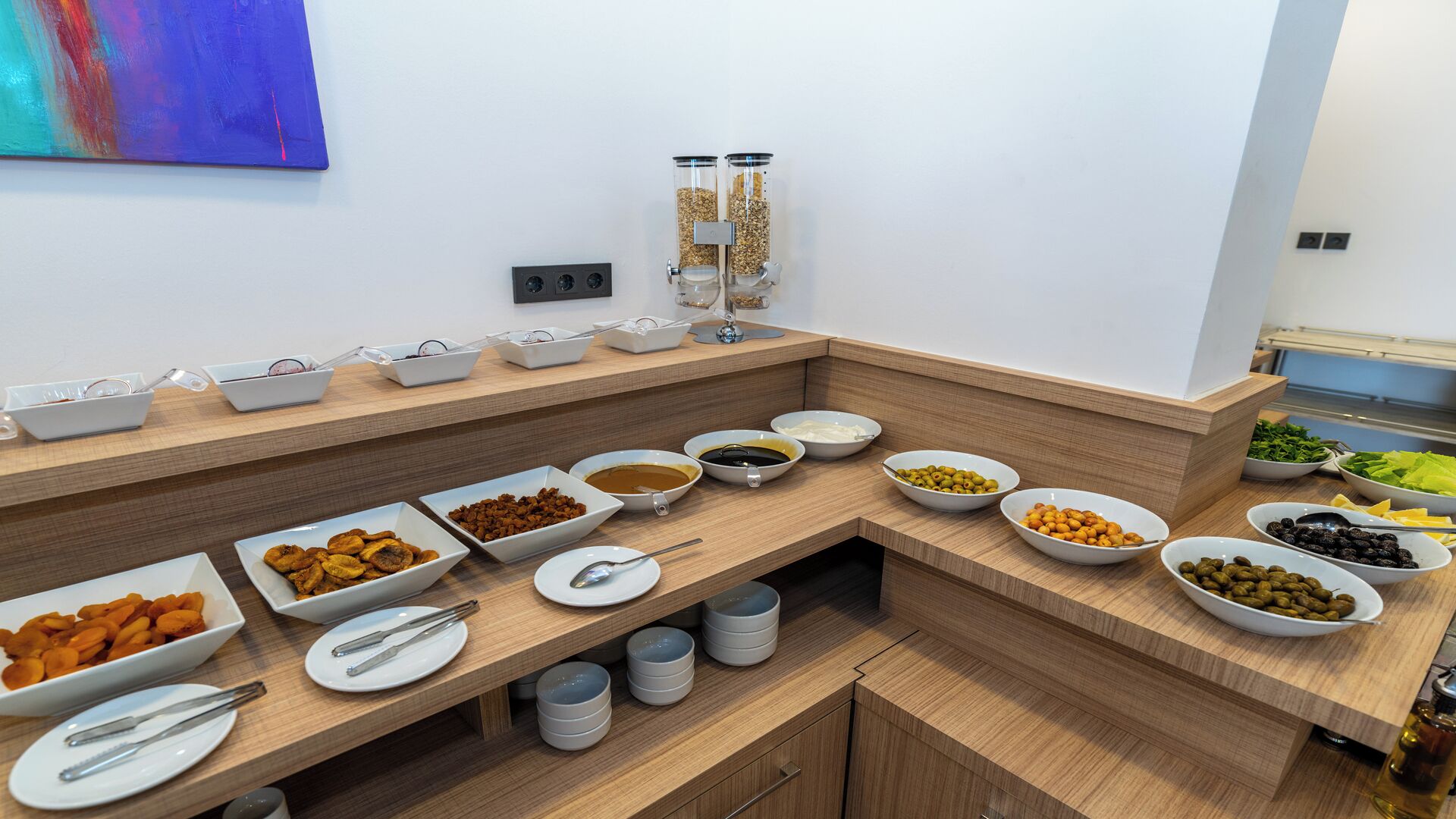 A buffet setup with various food items and utensils.