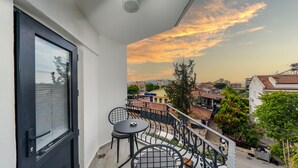 A balcony with a view of a cityscape during sunset. - Skykhan Otel (Fethiye)