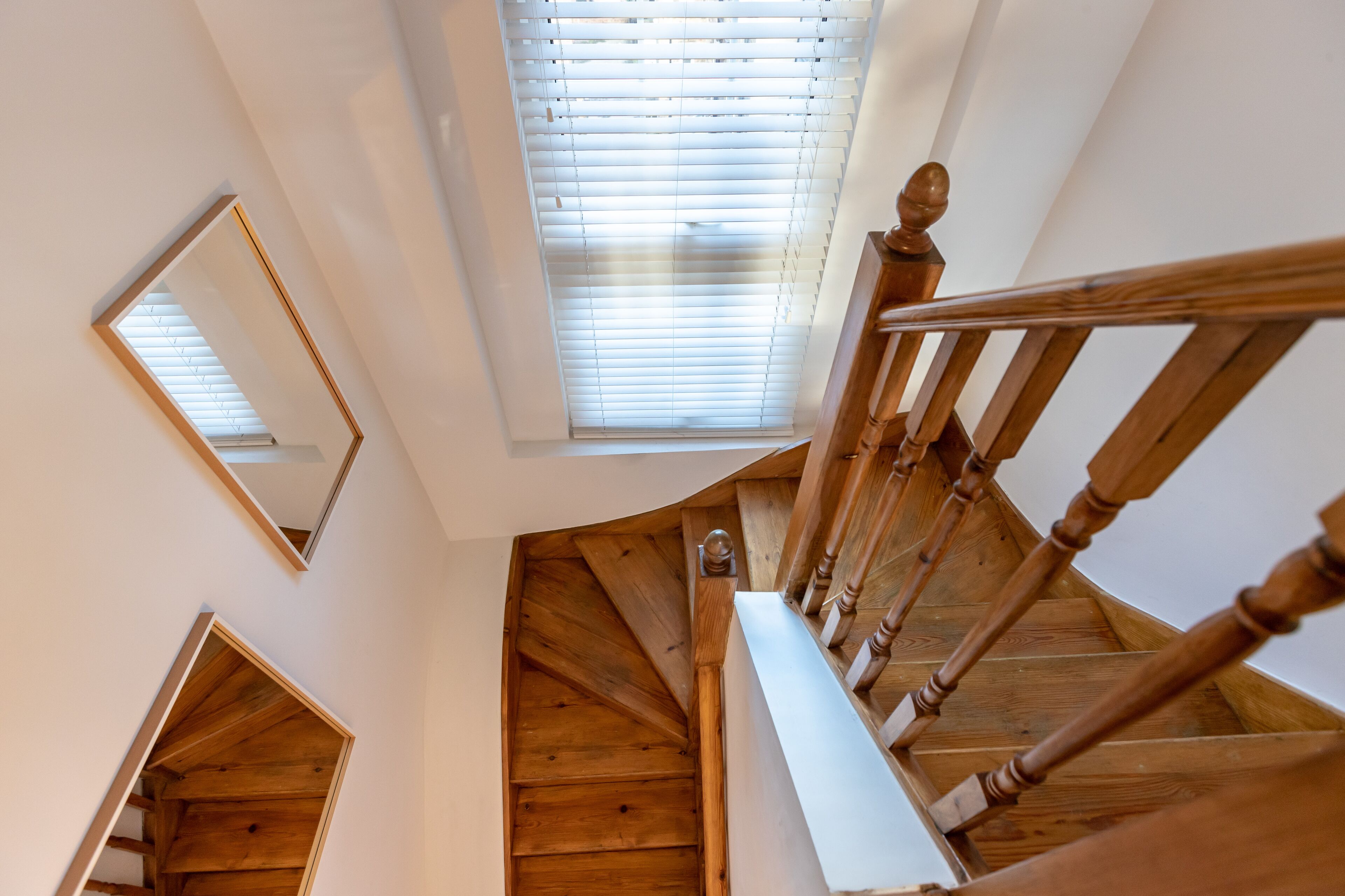 A wooden staircase with a handrail and a view of the ceiling.