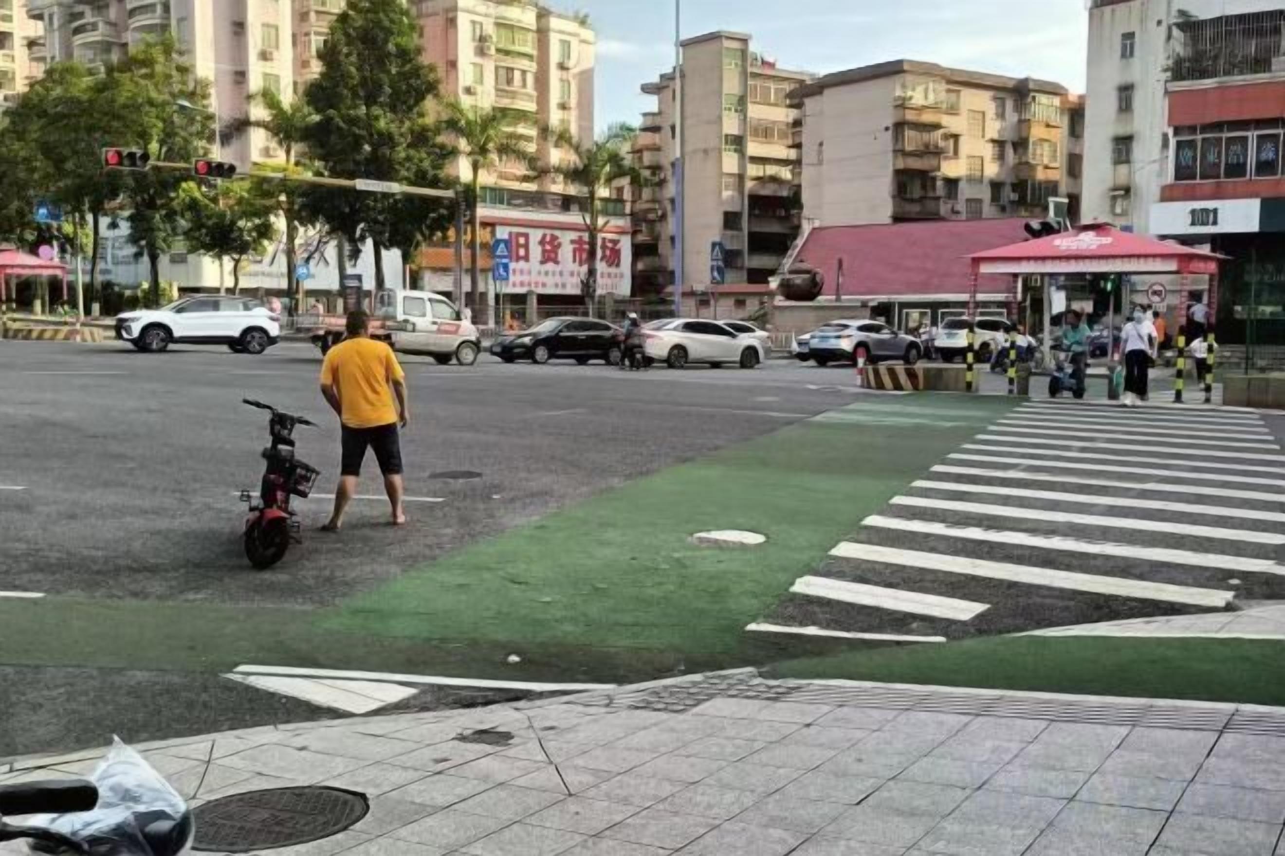 A pedestrian crossing with a zebra pattern, a parked motorcycle, and a person in a yellow shirt.