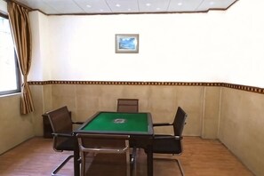 Quarto com mesa de bilhar, quatro cadeiras, janela com cortinas e um quadro na parede.