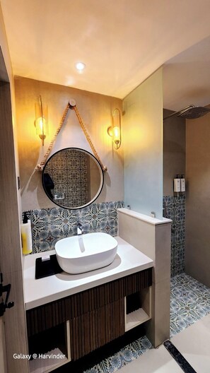 A modern bathroom with a round mirror, a white sink, and patterned tiles. - The Wave International Resort, Jamshedpur (Golmuri)