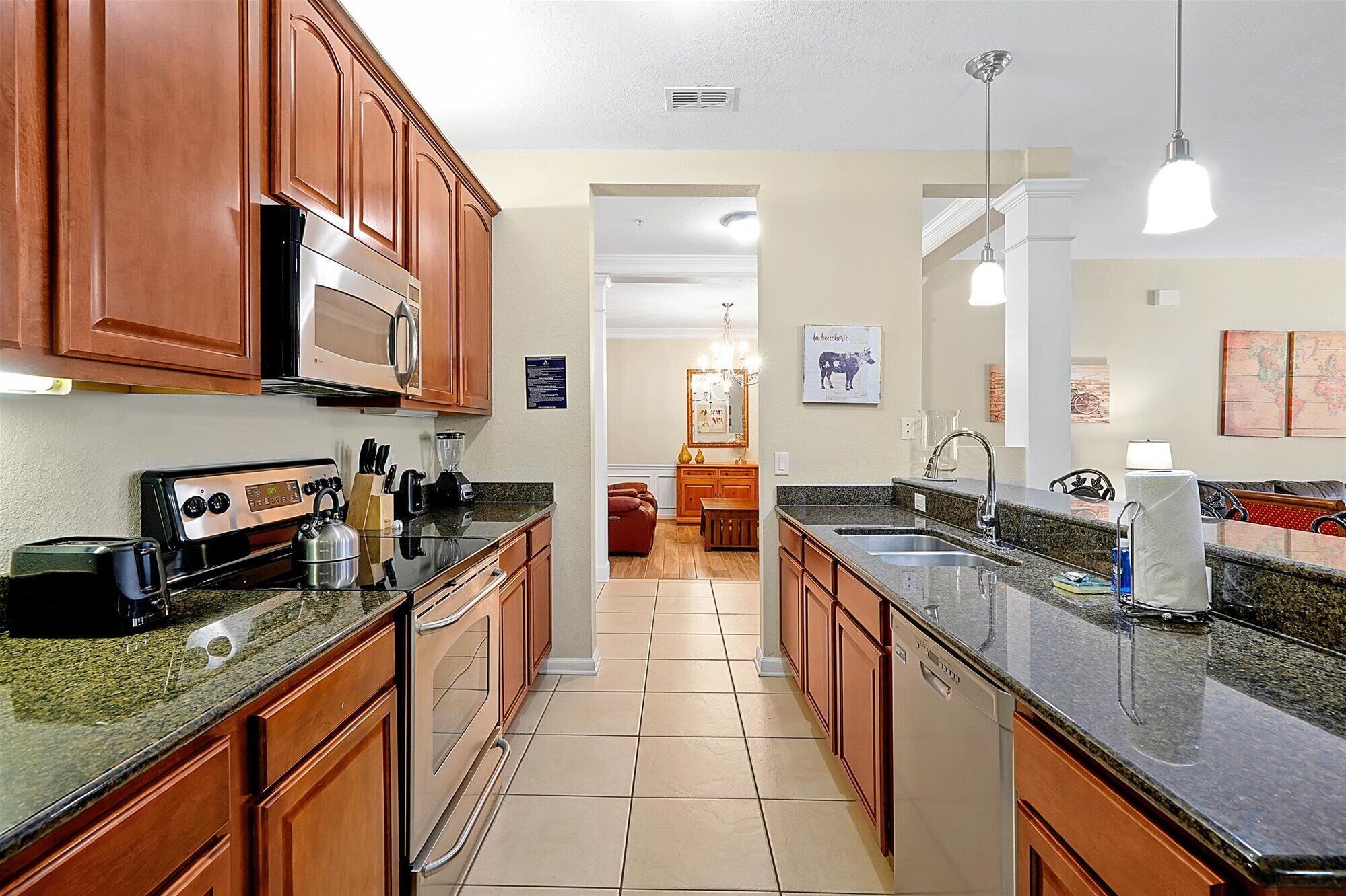 A kitchen with wooden cabinets, a microwave, a toaster, and a sink.