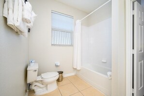 A bathroom with a toilet, a shower, and a window. - Beautiful Vacation Condo, Vista Cay Resort 3014 (Orlando)