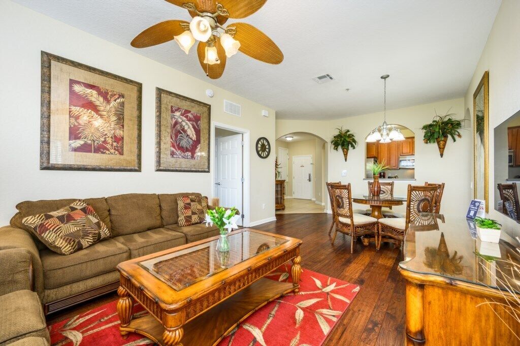 A living room with a sofa, coffee table, and dining area with chairs.