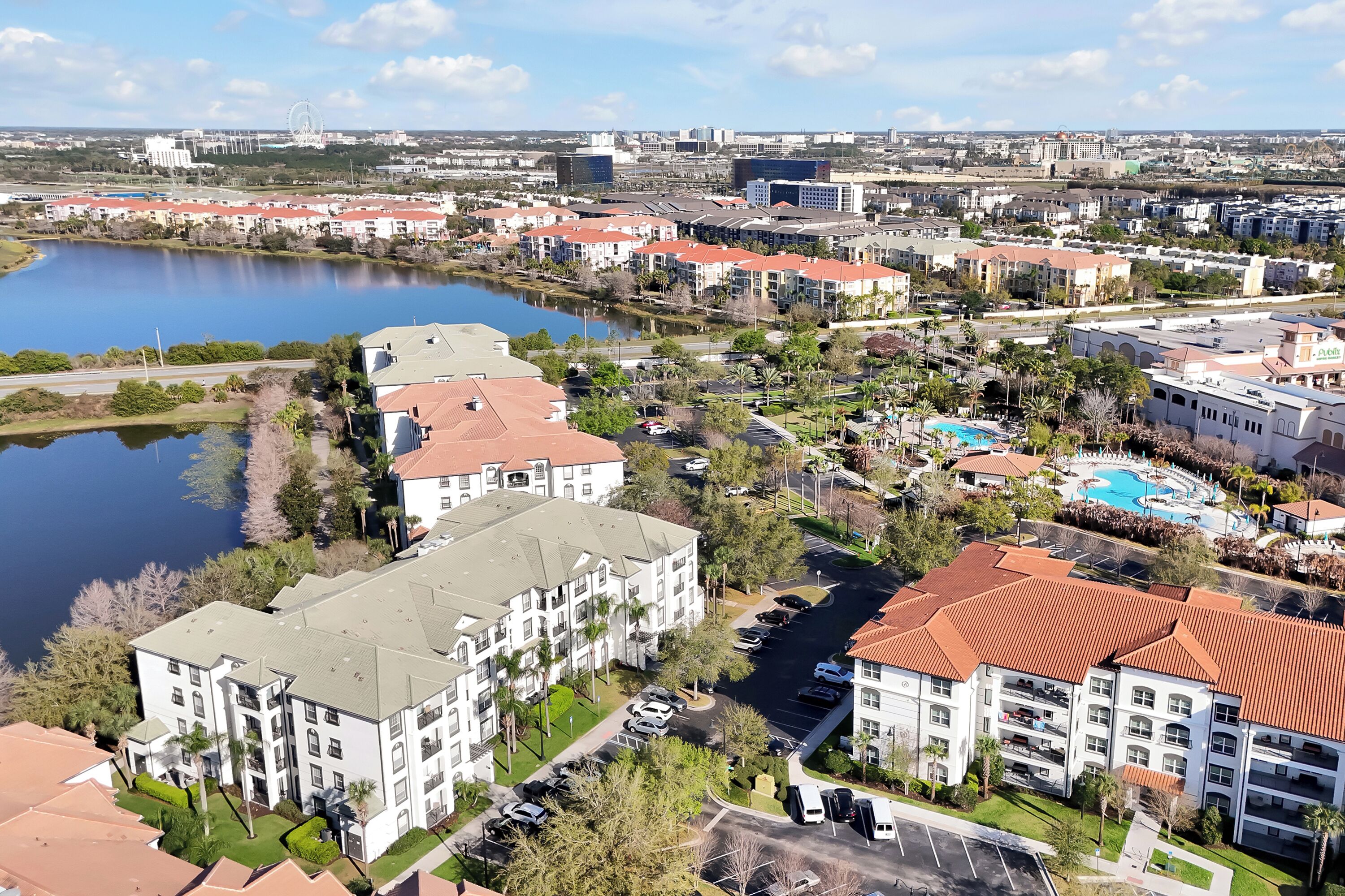 A residential area with apartment buildings, a lake, and a swimming pool.