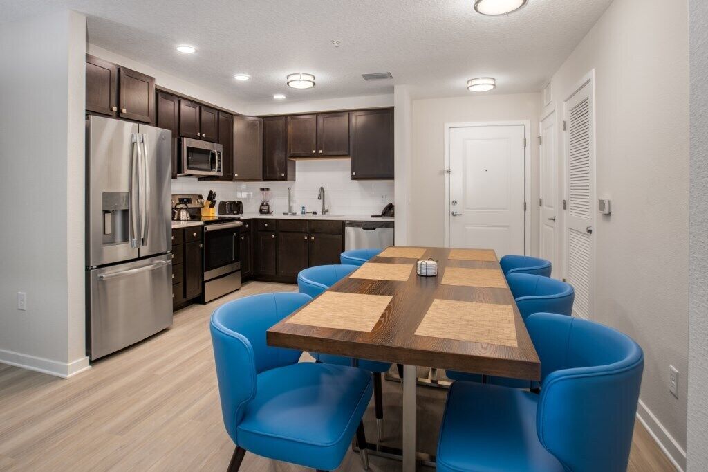 A compact kitchen with dark cabinets, stainless steel appliances, and a central island.