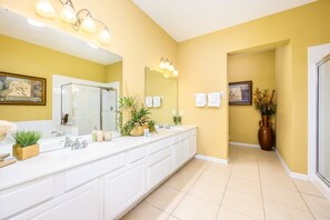 A spacious bathroom with a large white vanity, a mirror, and multiple light fixtures. - Tropical Lakeview Condo w. Vegas Game Room - 1014 (Orlando)