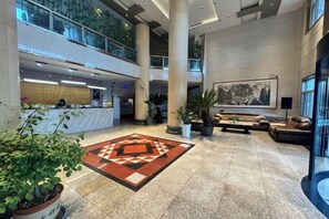 A spacious lobby with a reception desk, seating area, and large windows. - Mingya Hotel (Bohai International Plaza) (Binzhou)