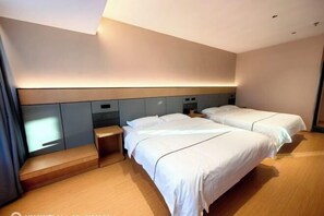 A hotel room with two beds, a small desk, and a built-in bench. - Mingya Hotel (Bohai International Plaza) (Binzhou)