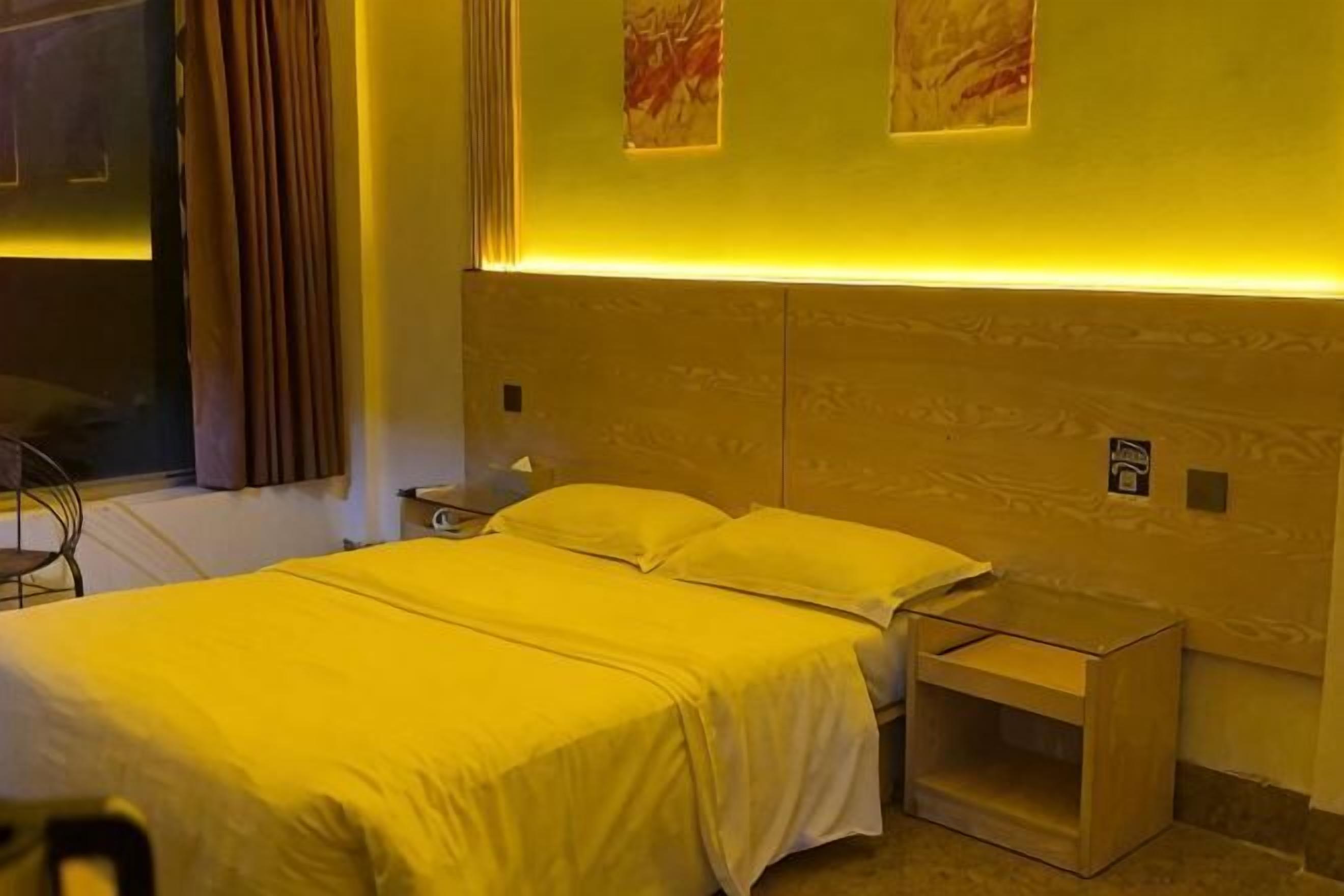 Cama doble con cabecera, mesitas de noche y mesilla.