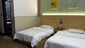 A hotel room with two single beds, a wooden headboard, a nightstand, and a small table. - Nanning City Hui Hotel (Jiuquwan Hot Spring) (Nanning)