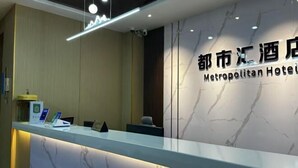 A reception desk with a marble wall and a sign that reads "Metropolitan Hotel". - Nanning City Hui Hotel (Jiuquwan Hot Spring) (Nanning)