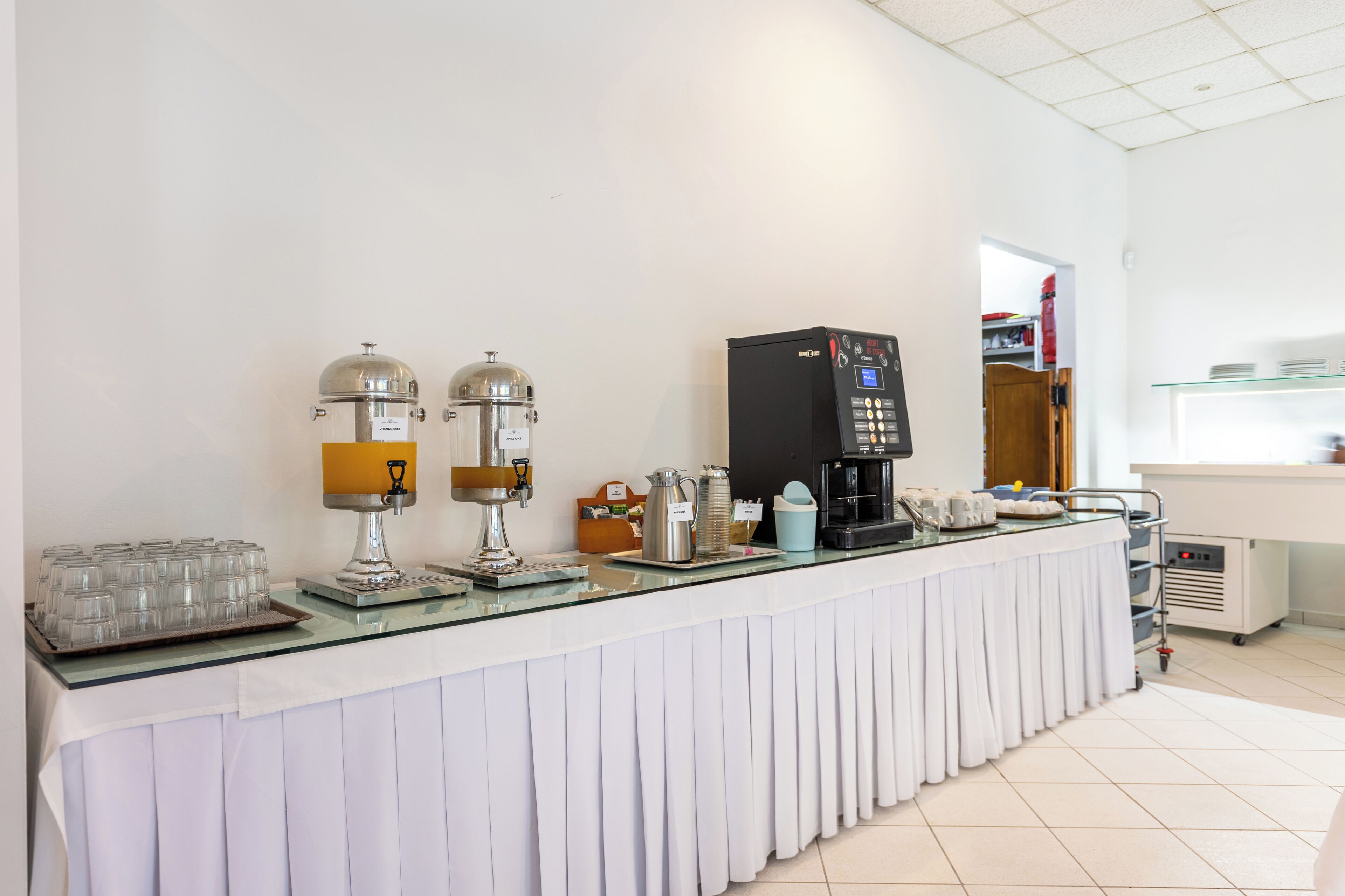 A coffee station with two espresso machines, a coffee maker, and a coffee dispenser.
