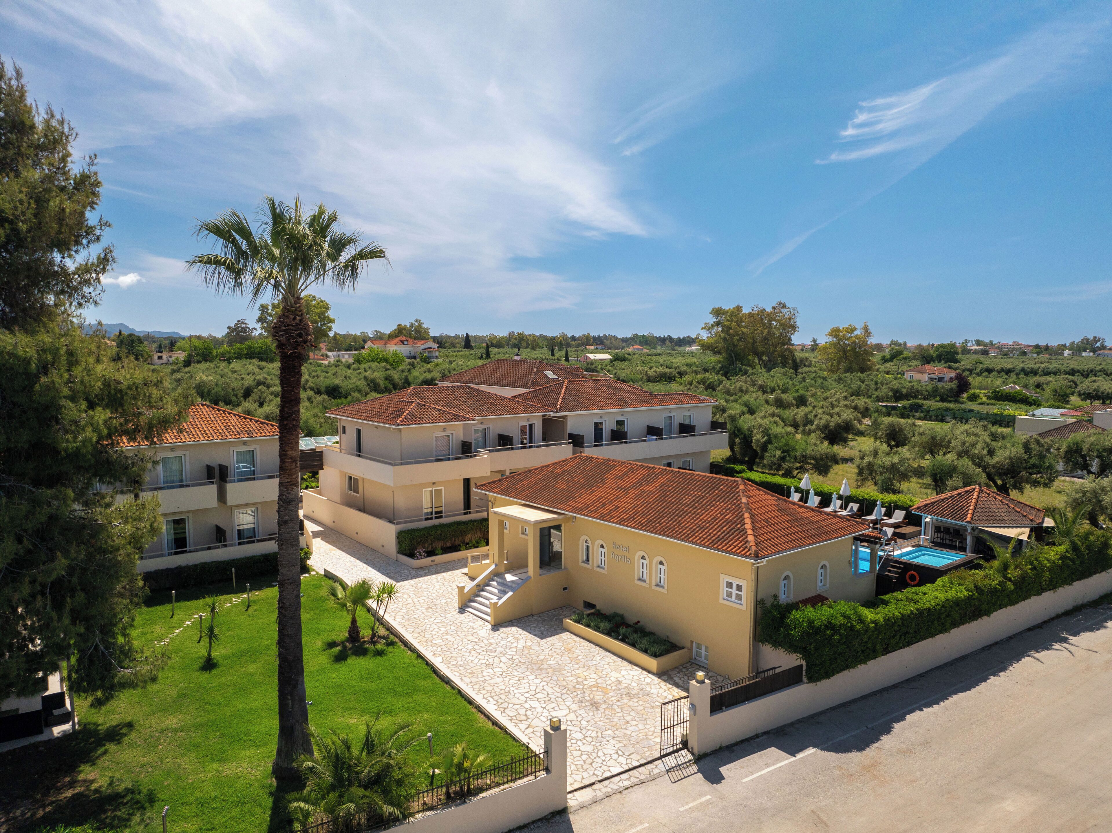 A residential complex with multiple two-story buildings, a swimming pool, and a well-maintained garden.