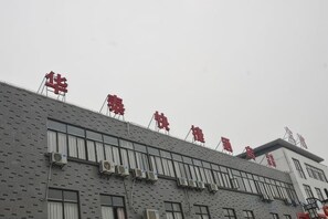 A building with multiple floors and a series of windows. - Huatai Express Chain Hotel (Wuxi)