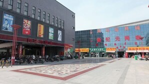 Ein Geschäftsgebäude mit mehreren Schaufenstern, darunter ein Restaurant und ein Geschäft mit großer chinesischer Beschilderung.