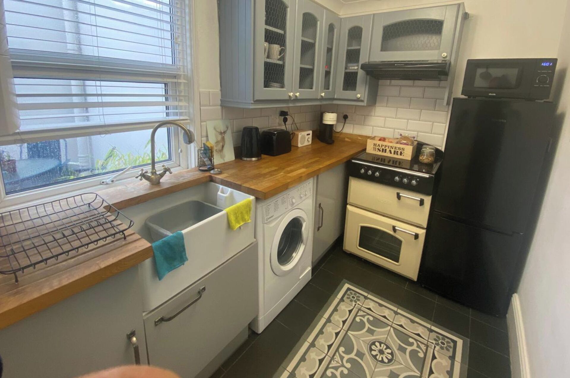 Una cocina compacta con lavabo, lavadora, estufa y refrigerador.