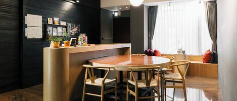 A modern dining area with a round table, wooden chairs, and a counter.