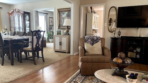 A living room with a dining area, a TV, and a fireplace. - Elegant Crofton Ranch (Augusta)