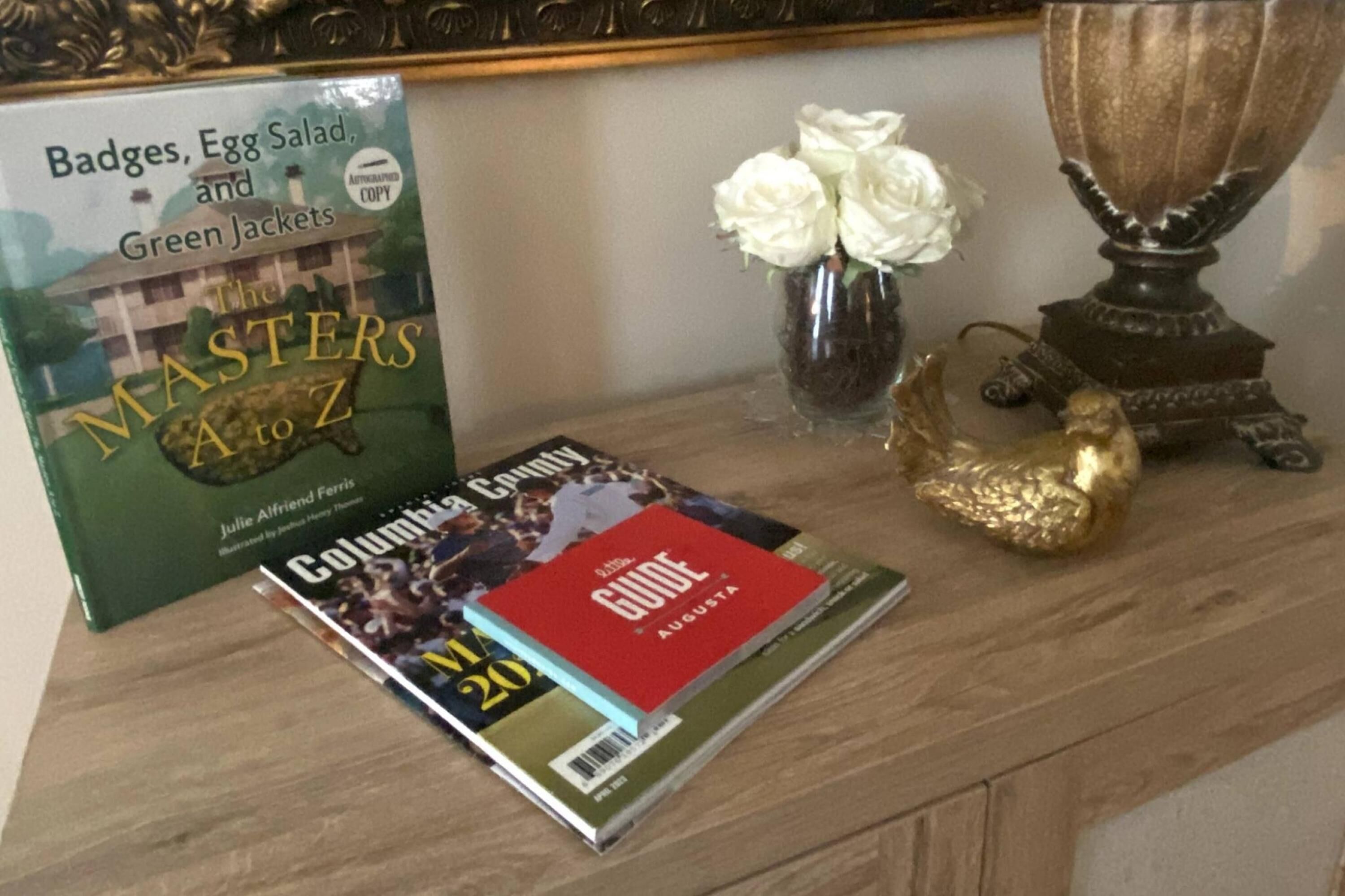 Un libro titulado 'The Masters A to Z' y una revista 'Columbia County Guide' sobre una mesa de madera.