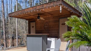 Une cabane en bois avec une piscine, un espace salon extérieur et un ventilateur de plafond.
