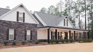 A two-story house with stone exterior walls and a covered porch.