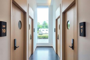 Un corridoio d'albergo con porte identificate con le scritte 'VIP 10' e 'VIP 7', che conducono alle stanze.