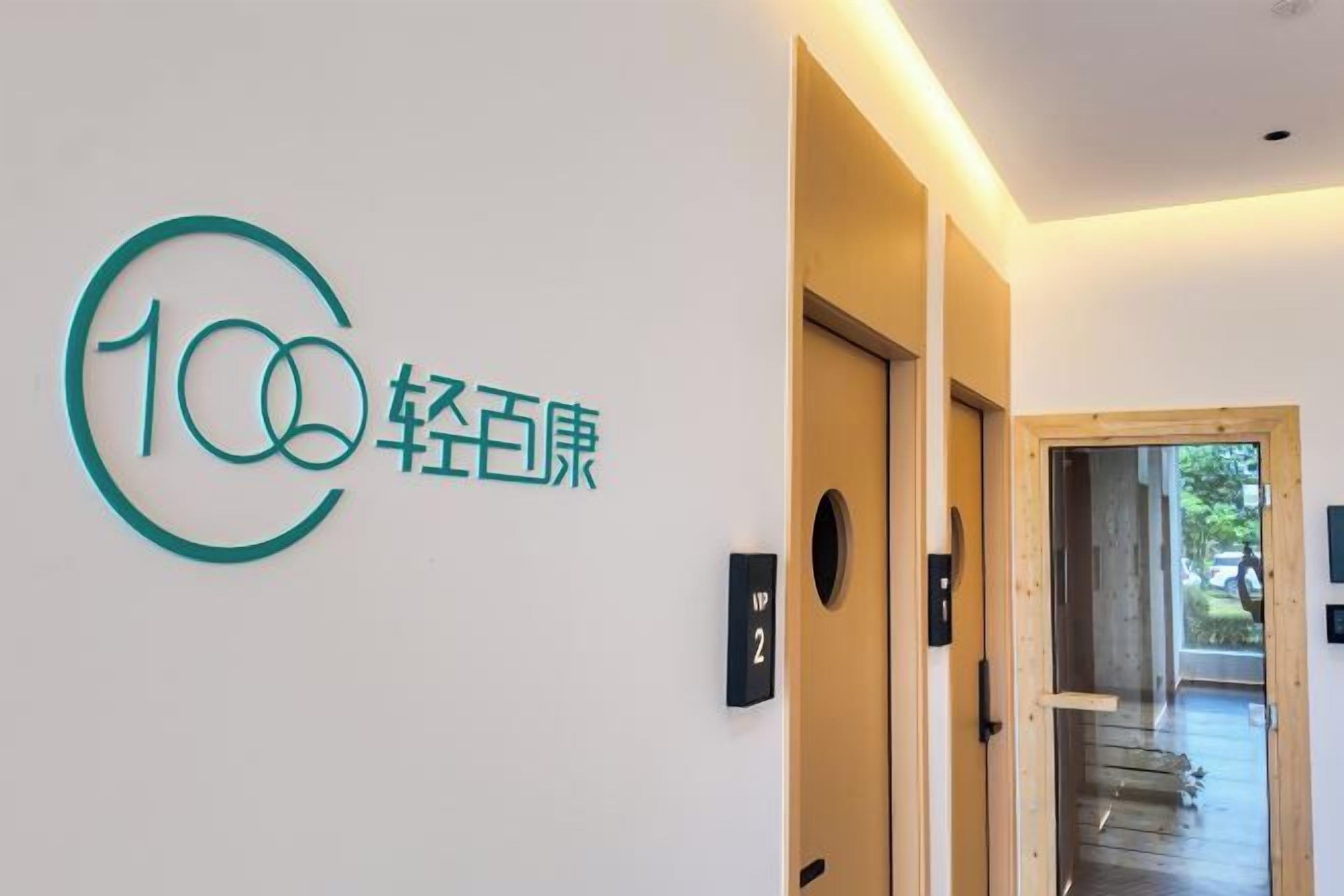 A hallway with a sign indicating the number 100 and the name '轻百康' in Chinese characters.