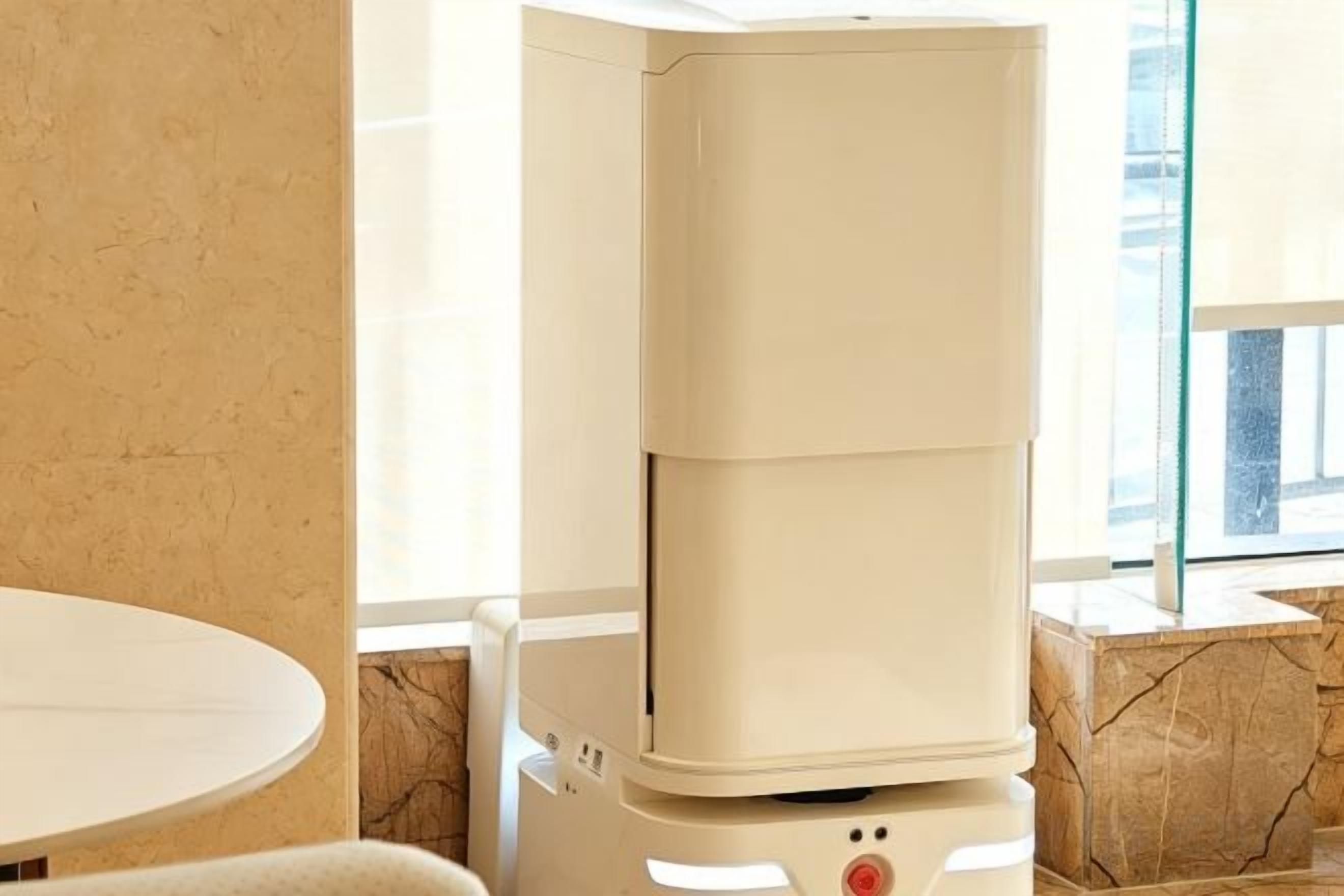 A corner of a room with a white table and a beige, modern-looking heater or appliance.