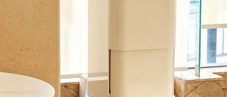 A corner of a room with a white table and a beige, modern-looking heater or appliance.