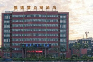 A multi-story hotel with a red facade and a sign indicating it is a public hotel.