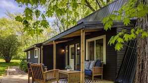 A wooden deck with a sofa and chairs, a small table, and a potted plant. - Lake View Hot Tub Modern A-frame (Rockbridge)