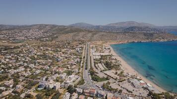 An aerial view of a coastal town with a beach, roads, and residential areas.