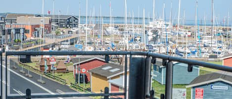 A marina with numerous boats docked, a speed limit sign, and a building labeled "Sandskulptur".