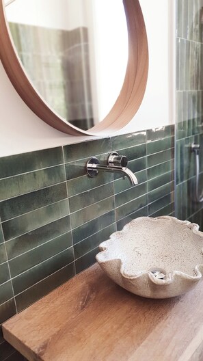 A bathroom with a wooden countertop, a round mirror, and a sink with a unique, scalloped edge design. - Residenza Villa Genua (Bordighera)