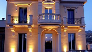 A large, two-story building with a central balcony, large windows, and a symmetrical facade. - Residenza Villa Genua (Bordighera)