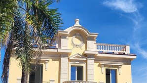 A two-story building with a balcony, large windows, and a decorative entrance. - Residenza Villa Genua (Bordighera)