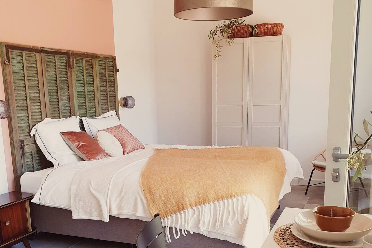 Une chambre à coucher comprenant un lit, une table de chevet et un coin repas avec une table et des chaises.