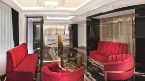 A modern hotel lobby with red sofas, a marble floor, and a glass coffee table. - Silvana Hotel (Istanbul)