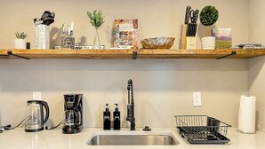 A modern kitchen with a stainless steel sink, a coffee maker, a dish rack, and a book on Italian cuisine. - This apartment is a 2 bedroom(s), 1 bathrooms, located in Berkley, MI. (Berkley)