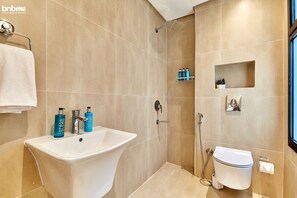 A modern bathroom with a freestanding bathtub, a toilet, and a shower area. - bnbmehomes-2BR nr Boulevard City-D13 (Riyadh)