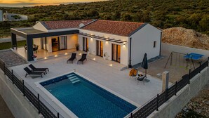A modern house with a swimming pool, outdoor seating, and a patio area. - Villa Cesarica (Polaca)