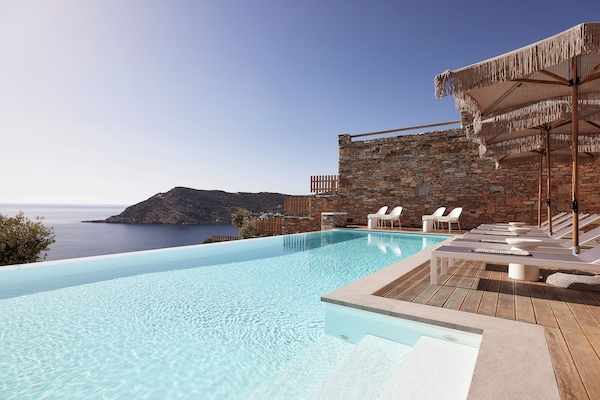 Una piscina al aire libre de temporada, sombrillas, tumbonas