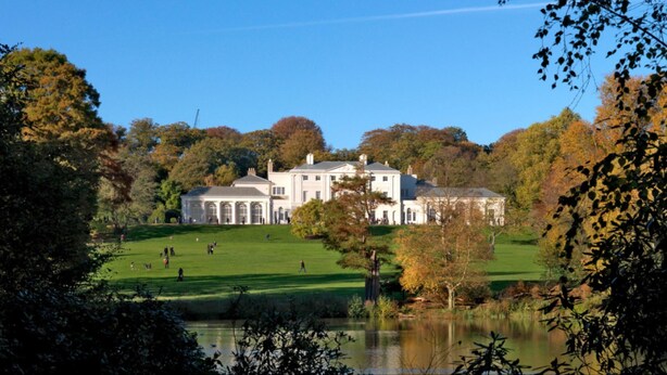 A large, historic building with a symmetrical facade, surrounded by a well-maintained lawn and a body of water. - Private Garden Flat Central London Air Conditioning (London)